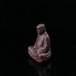 This is a purple clay tea pet with the image of Trump.