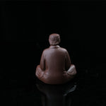 This is a purple clay tea pet with the image of Trump.