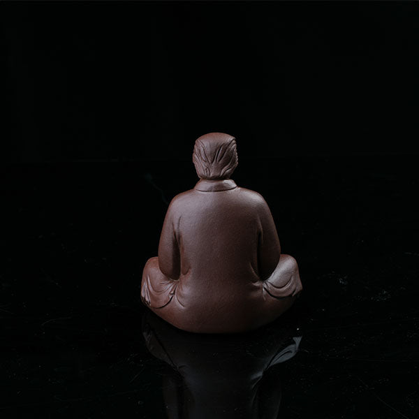 This is a purple clay tea pet with the image of Trump.