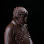 This is a purple clay tea pet with the image of Trump.
