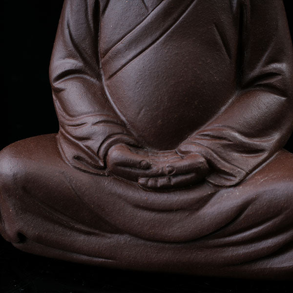 This is a purple clay tea pet with the image of Trump.