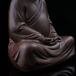 This is a purple clay tea pet with the image of Trump.