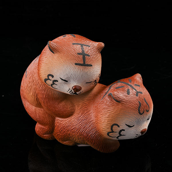 This is a purple clay tea pet with two little tigers hugging and sleeping.