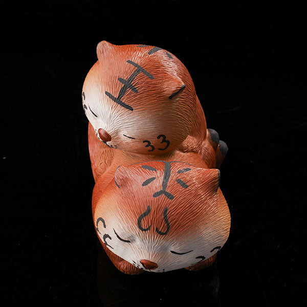 This is a purple clay tea pet with two little tigers hugging and sleeping.
