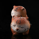 This is a purple clay tea pet with two little tigers hugging and sleeping.