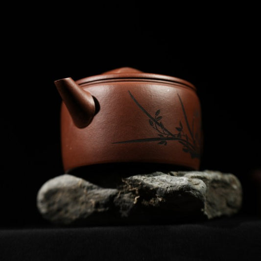 This is a handmade Yixing purple clay teapot, made by Master Chen Xiaozhong. There are bamboo leaves carved on the left side of the teapot, and the four characters "Hou De Zai Wu" are written on the right side.