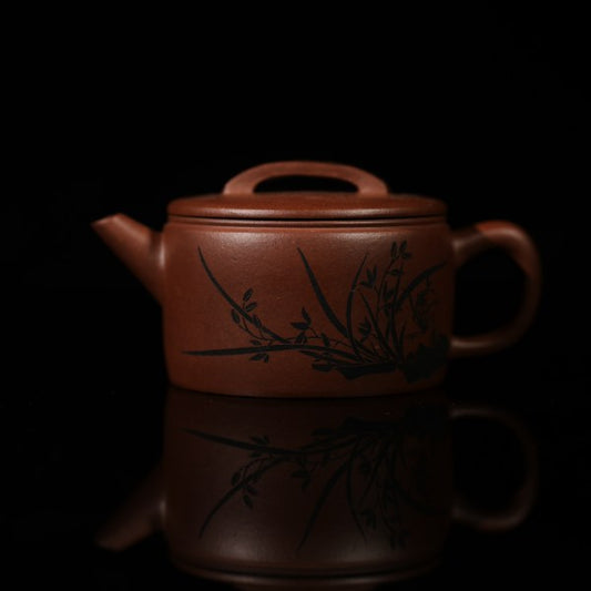 This is a handmade Yixing purple clay teapot, made by Master Chen Xiaozhong. There are bamboo leaves carved on the left side of the teapot, and the four characters "Hou De Zai Wu" are written on the right side.
