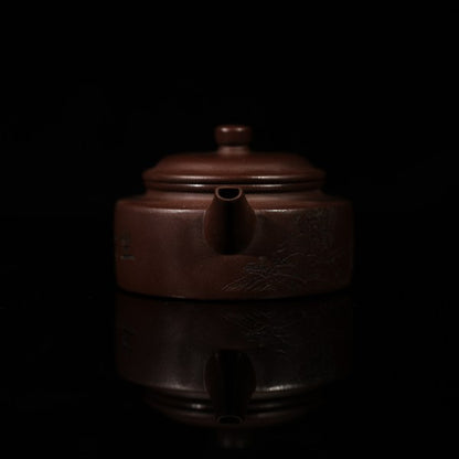 This purple clay teapot is dark brown in color, with a Chinese garden landscape of a small bridge and flowing water painted on the left side of the teapot, and the words "Sitting and Drinking Tea" engraved on the right side. This purple clay teapot was made by Chinese purple clay teapot master Chen Xiaozhong and was produced in Yixing, a famous purple clay teapot production area in China.